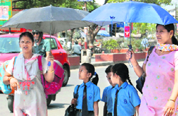 Children in Dehradun being escorted home by their mothers in the scorching heat on Friday.