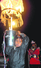 A young boy holds a chandelier at a marriage procession in Dehradun.