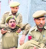 Cops take a colleague to a hospital after he was injured in an anti-election protest at Srinagar on Friday