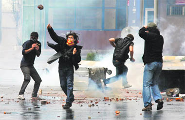 Protesters throw stones at Turkish riot police as they use tear gas to disperse crowds gathered for an outlawed May Day rally in central Istanbul on Friday.