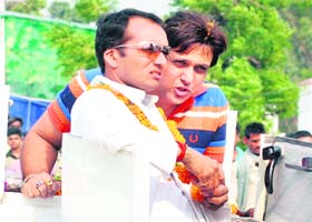 Cine star Govinda and Congress candidate for the Kurukshetra Lok Sabha seat Naveen Jindal share a point during a road show