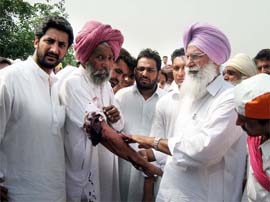 Ajit Inder Singh Mofar, MLA Sardulgarh, showing the injuries of Zile Singh, a party worker, allegedly assaulted by SAD (B) activists at village Adam Ke in Mansa