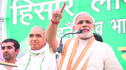 Gujarat Chief Minister Narendra Modi makes a point while addressing an election meeting in Hisar on Monday as NDA candidate for the Hisar Lok Sabha seat Sampat Singh looks on.