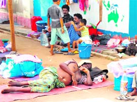 A man rests on a mat as other Tamil civilians and their children sit near their belongings in a refugee camp located on the outskirts of Vavuniya in northern Sri Lanka on Monday. The Sri Lankan military denied a report on Saturday by a pro-rebel website of killing 64 persons by shelling a makeshift hospital inside the last scrap of land held by the the LTTE, saying the rebels may have set off explosions near the hospital. 