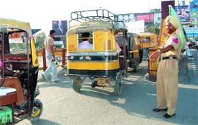 A policeman guiding three-wheelers to divert to the sidelane of the Bhandari Bridge to avoid frequent traffic jams