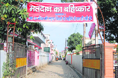 A banner, put up by residents, demands boycott of elections in protest against non-completion of this road at Dehradun.