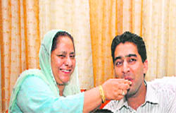 Elated mother offering laddoosto Shahid