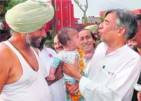 Congress candidate Pawan Bansal gets up and close with a little supporter during his campaign trail in Chandigarh