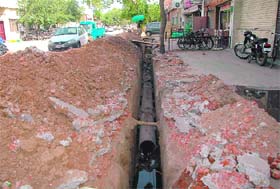 A customer jumps over the trench to reach a shop in Industrial Area, Phase II