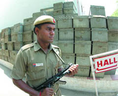 A security person guards the EVMs at a polling station in New Delhi on Wednesday.