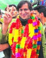 Peoples Conference chairman Sajad Gani Lone flashes the victory sign during a road show at Uri in Srinagar on Wednesday.