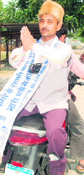 Mohammad Murslin Qureshi campaigns on a two-wheeler.