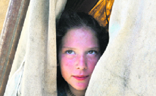 A Pakistani girl, fleeing from military operations against Taliban militants in Buner, looks from inside her tent at a makeshift camp in Islamabad on Thursday.
