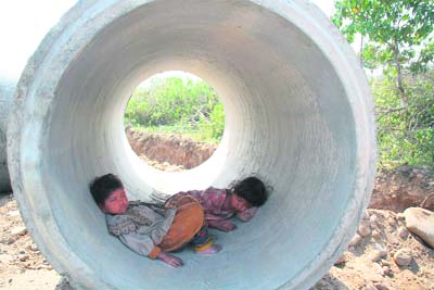 Children of a labourer try to beat the heat on the outskirts of Jammu