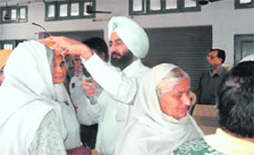 Dr Sukhdip S Boparai, chief consultant of the Patiala Eye Hospital and Lasik Laser Centre, examines a patient at Patiala on Friday.
