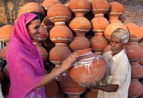 A lady checks a pitcher before purchasing one from a seller in Bathinda