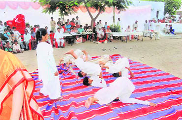 Students of Kanya Gurukul perform yoga asanas on the campus
