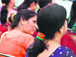 Women wear saffron and green hairbands, distributed by the BJP, at an election rally in Chandigarh on Sunday