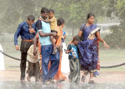A family caught in the unexpected rain at the India Gate in New Delhi on Sunday. 