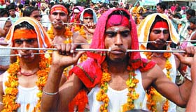 Tamil youths, with iron rods pierced through their cheeks, take part in religious procession on the occasion of Pongal in Amritsar
