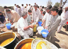 Children wait to receive food at a refugee camp at Swabi in northwest Pakistan on Sunday.