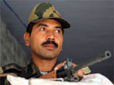 A BSF personnel keeps vigil at a school where electronic voting machines (EVMs) have been kept in Bathinda on Monday.