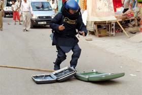 A member of the bomb disposal squad checks an unidentified suitcase at the Sadar Bazar in Gurgaon