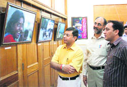 People visit a photo exhibition organised by the Jammu Photojournalist Association at the Jammu Press Club on Monday.