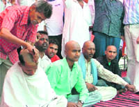 Congress workers shave their heads in Ludhiana on Sunday.