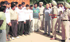 A cop gives tips to thikri pehra volunteers in Ahmedgarh on Sunday.