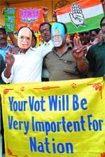 Men wearing masks of L.K. Advani and Manmohan Singh spread a message of voting