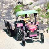 A tractor engaged in mining in the Neugal river near Palampur.