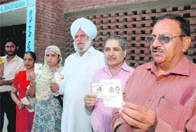 Residents show their voter cards after they were denied votes outside a polling booth in Sector 45A, Chandigarh