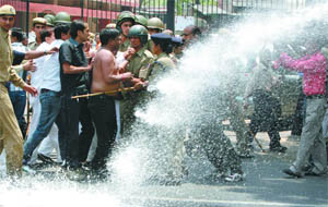 Policemen use water cannons to disrupt parents protesting against school fee hike at Jantar Mantar in New Delhi on Wednesday.