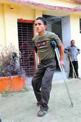 A young voter on crutches arrives to cast his vote at a polling station in Dehradun.