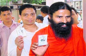 Yoga guru Ramdev and his protege Acharya Balakrishan line up to vote at the Kankhal centre in Haridwar