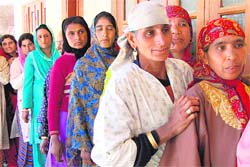 Kashmiri women queue up outside a polling booth at Handwara in Kupwara district on Wednesday