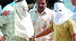 Crime branch officials present the two persons arrested for killing a man at Jamia Nagar in New Delhi on Friday.