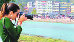 A young Russian tourist takes pictures of Ganga Ghats in Haridwar; and (below) Brazilian tourists at Swami Vivekananda Park.