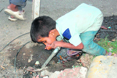 A child quenches his thirst at a ground-level standpost on Chakrata Road in Dehradun.
