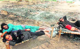 Gujjar women are forced to live in the open at Belicharana village after the destruction of their huts in a fire during an anti- encroachment drive.