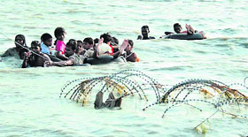 In a photograph released by the Sri Lankan army on Friday, civilians are seen using inflatable tubes across a lagoon to escape the islands war zone.