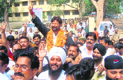 Victorious Congress candidate flashes a victory sign to his supporters in Kathua on Saturday.