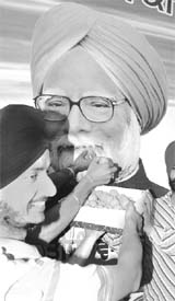 A youth offers sweets to the picture of Manmohan Singh during the victory celebrations of the Congress in Patiala on Sunday