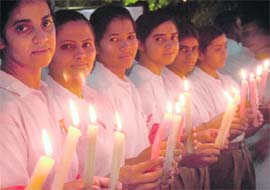 Girls hold candles on the 26th International AIDS Candlelight Memorial Day in memory of those who lost battle to HIV/AIDS, at Sector 17, Chandigarh, on Sunday.