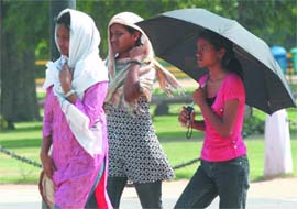 ITS MUGGY: Girls cover their faces to protect themselves from the scorching heat in New Delhi on Sunday.