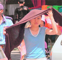 A girl protects herself from the scorching sun in Gurgaon.