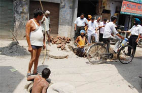 Municipal Corporation employees  clear sewer as the MC Commissioner visits the affected areas where contaminated water was being supplied, in Amritsar on Tuesday. 