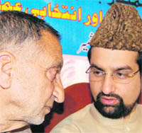 APHC Chairman Mirwaiz Umar Farooq  (right) confers with senior Hurriyat leader Abdul Ghani Bhat during  a seminar in Srinagar on Tuesday.