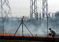 An employee of the PSEB dousing the flames that erupted at a grid opposite the Guru Nanak Dev Thermal Power Plant in Bathinda on Wednesday.